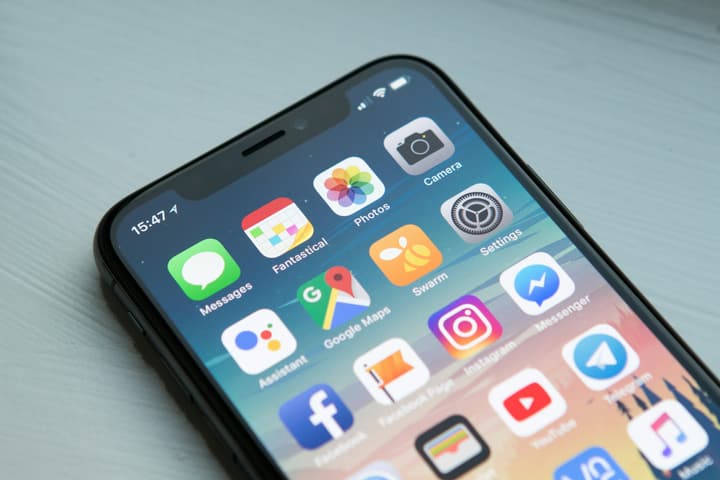 Une main tenant un smartphone, une page web en cours de chargement à l’écran.