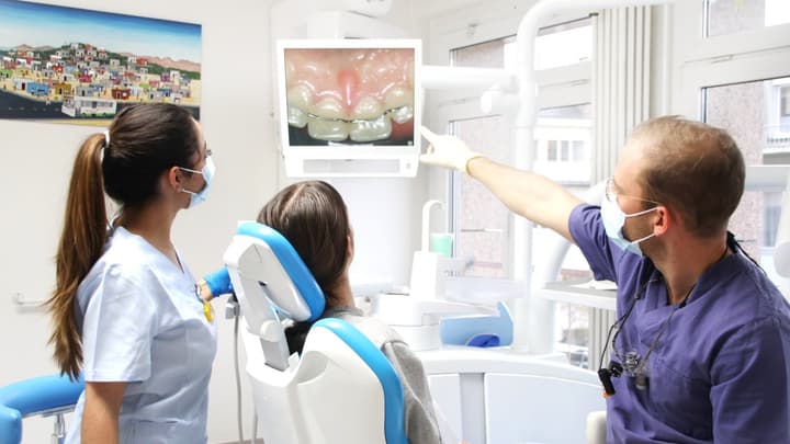 Une dentiste du Centre Dentaire Dr Haerri montre à une patiente son scan intra-oral sur l’écran chairside.